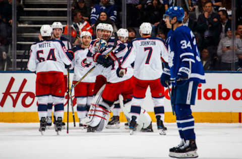 TORONTO, ON – JANUARY 8: Members of the Columbus Blue Jackets celebrate their overtime win as Auston Matthews #34 of the Toronto Maple Leafs leaves the ice at the Air Canada Centre on January 8, 2018 in Toronto, Ontario, Canada. (Photo by Mark Blinch/NHLI via Getty Images)