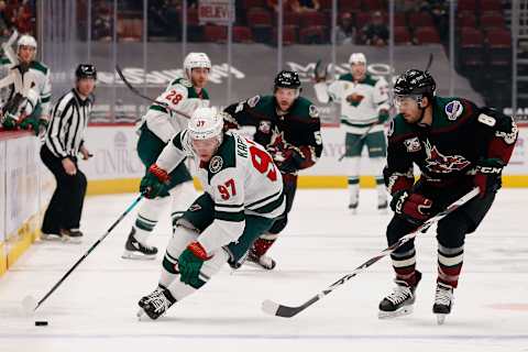 GLENDALE, ARIZONA – APR. 19: Kirill Kaprizov #97 of the Minnesota Wild skates with the puck ahead of Nick Schmaltz #8 of the Arizona Coyotes during the NHL game at Gila River Arena on Apr. 19, 2021 in Glendale, Arizona. (Photo by Christian Petersen/Getty Images)