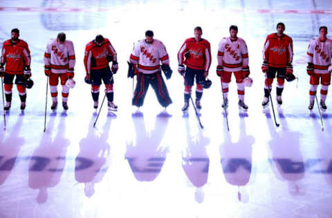 The Washington Capitals and the Carolina Hurricanes stand together  (Photo by Andre Ringuette/Freestyle Photo/Getty Images)