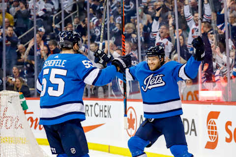 WINNIPEG, MB – MARCH 16: Mark Scheifele #55 and Ben Chiarot #7 of the Winnipeg Jets celebrate a first period goal against the Calgary Flames at the Bell MTS Place on March 16, 2019 in Winnipeg, Manitoba, Canada. (Photo by Darcy Finley/NHLI via Getty Images)