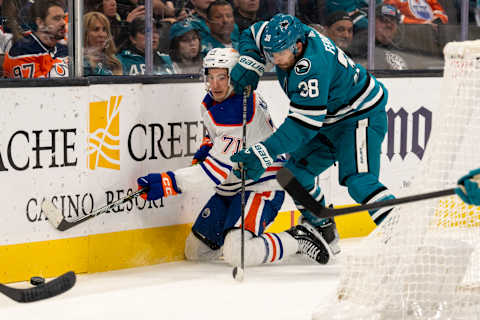 Nov 9, 2023; San Jose, California, USA; Edmonton Oilers center Ryan McLeod (71) and San Jose Sharks defenseman Mario Ferraro (38) battle for the puck on the boards behind the net during the first period at SAP Center at San Jose. Mandatory Credit: Neville E. Guard-USA TODAY Sports