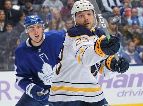 TORONTO, ON – NOVEMBER 30: Sam Reinhart #23 of the Buffalo Sabres knocks down a high puck against Justin Holl #3 of the Toronto Maple Leafs during an NHL game at Scotiabank Arena on November 30, 2019 in Toronto, Ontario, Canada. The Maple Leafs defeated the Sabres 2-1 in overtime. (Photo by Claus Andersen/Getty Images)