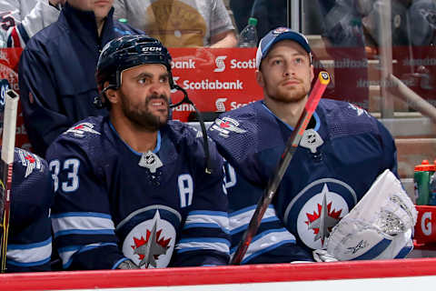 WINNIPEG, MB – DECEMBER 27: Dustin Byfuglien #33 of the Winnipeg Jets gets his game face on while he and teammate Laurent Brossoit #30 look on from the bench prior to puck drop against the Calgary Flames at the Bell MTS Place on December 27, 2018 in Winnipeg, Manitoba, Canada. (Photo by Jonathan Kozub/NHLI via Getty Images)