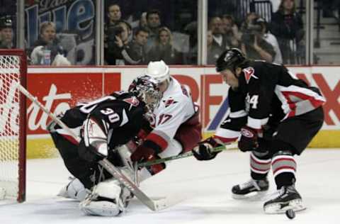 Ryan Miller #30 of the Buffalo Sabres makes a pad save on Hurricanes’ Rod Brind’Amour #17 as Sabres’ Jay McKee #74 clears the puck during game 3 of the Eastern Conference Finals versus the Carolina Hurricanes at the HSBC Arena in Buffalo, New York, May 24, 2006. (Photo by Jerome Davis/NHLImages)