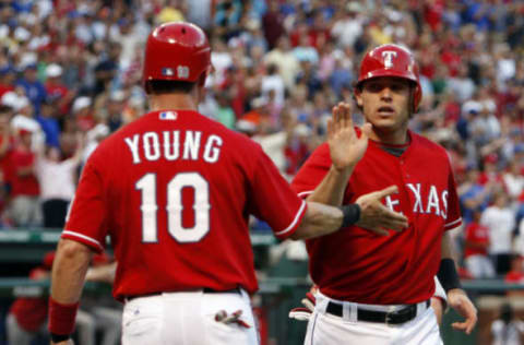 Michael Young high-fives Ian Kinsler after they both scored against the Los Angeles Angels on a triple by Josh Hamilton at Rangers Ballpark in Arlington, Texas, Sunday July 25, 2010. (Photo by Richard W. Rodriguez/Fort Worth Star-Telegram/MCT via Getty Images)