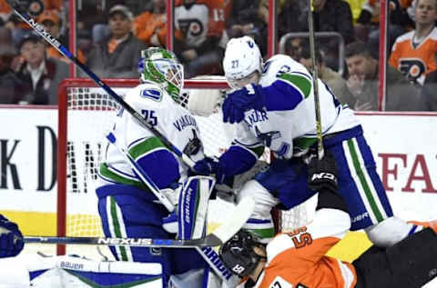 Dec 17, 2015; Philadelphia, PA, USA; Philadelphia Flyers defenseman Nick Schultz (55) gets tangled with Vancouver Canucks defenseman Ben Hutton (27) and goalie Jacob Markstrom (25) during the second period at Wells Fargo Center. Mandatory Credit: Eric Hartline-USA TODAY Sports