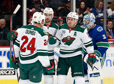 VANCOUVER, BC – DECEMBER 4: Anders Nilsson #31 of the Vancouver Canucks looks on as Zach Parise #11 of the Minnesota Wild is congratulated by teammates Matt Dumba #24 and Nino Niederreiter #22 after scoring during their NHL game at Rogers Arena December 4, 2018 in Vancouver, British Columbia, Canada. (Photo by Jeff Vinnick/NHLI via Getty Images)