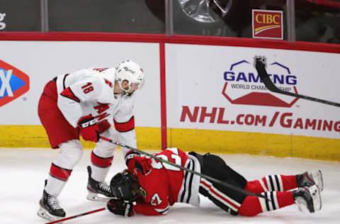 CHICAGO, ILLINOIS – MARCH 30: Cedric Paquette #18 of the Carolina Hurricanes holds down Adam Boqvist #27 of the Chicago Blackhawks after knocking him to the ice at the United Center on March 30, 2021 in Chicago, Illinois. The Blackhawks defeated the Hurricanes 2-1. (Photo by Jonathan Daniel/Getty Images)