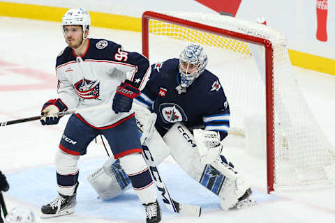 Dec 2, 2022; Winnipeg, Manitoba, CAN; Columbus Blue Jackets forward Jack Roslovic (96) and Winnipeg Jets goalie David Rittich (33) look for the puck during the third period at Canada Life Centre. Mandatory Credit: Terrence Lee-USA TODAY Sports