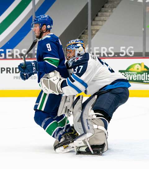 VANCOUVER, BC – MARCH 22: J.T. Miller #9 of the Vancouver Canucks tries to screen goalie Connor Hellebuyck #37 of the Winnipeg Jets. (Photo by Rich Lam/Getty Images)