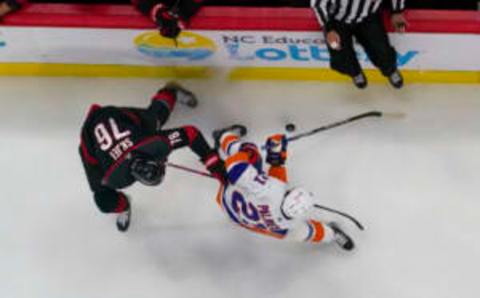 Apr 2, 2023; Raleigh, North Carolina, USA; Carolina Hurricanes defenseman Brady Skjei (76) and New York Islanders center Kyle Palmieri (21) battle over the puck during the first period at PNC Arena. Mandatory Credit: James Guillory-USA TODAY Sports