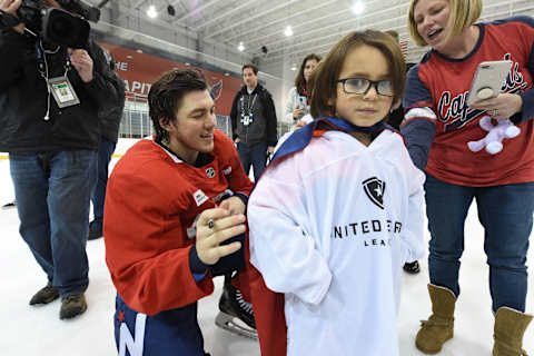 ARLINGTON, VA – MARCH 02: T.J. Oshie #77 of the Washington Capitals signs the jersey of a young family member of the UHL (United Heroes League) after the Washington Capitals practice as part of the 2018 NHL Stadium Series Annapolis Legacy Project event at Kettler Capitals Iceplex on March 2, 2018 in Arlington, Virginia. (Photo by Brian Babineau/NHLI via Getty Images)