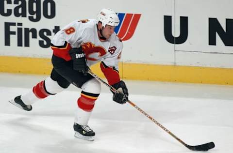 CHICAGO – NOVEMBER 12: Defender Robyn Regehr #28 of the Calgary Flames advances the puck against the Chicago Blackhawks during the game at the United Center on November 12, 2003 in Chicago, Illinois. The Flames won 6-2. (Photo by Jonathan Daniel/Getty Images)