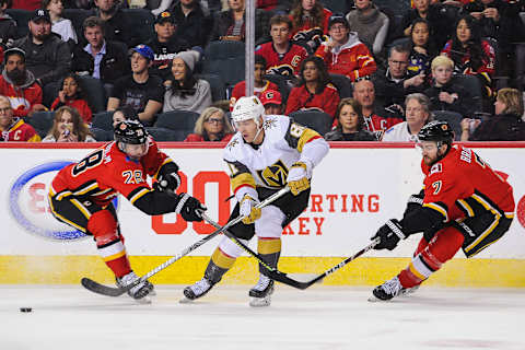 CALGARY, AB – MARCH 8: Jonathan Marchessault #81 of the Vegas Golden Knights carries the puck against Elias Lindholm #28 (L) and T.J. Brodie #7 of the Calgary Flames during an NHL game at Scotiabank Saddledome on March 8, 2020 in Calgary, Alberta, Canada. (Photo by Derek Leung/Getty Images)