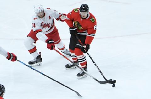 Feb 4, 2021; Chicago, Illinois, USA; Carolina Hurricanes defenseman Jaccob Slavin (74) defends Chicago Blackhawks left wing Dominik Kubalik (8) during the first period at United Center. Mandatory Credit: David Banks-USA TODAY Sports