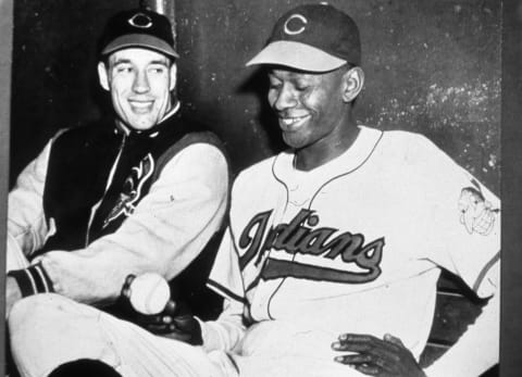 CLEVELAND – 1949: Bob Feller, left, and Satchel Paige, pitchers for the Cleveland Indians in 1949 pose for a photo in the Indians dugout. (Photo by Mark Rucker/Transcendental Graphics/Getty Images)