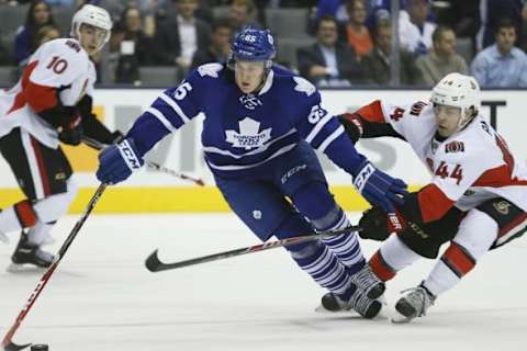 Sep 24, 2014; Toronto, Ontario, CAN; Toronto Maple Leafs defenceman Viktor Loov (65) tries to control the puck against Ottawa Senators forward Jean-Gabriel Pageau (44) during the first period at the Air Canada Centre. Mandatory Credit: John E. Sokolowski-USA TODAY Sports