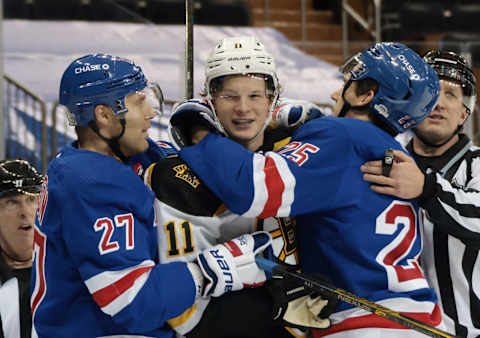 : Jack Johnson #27 and Libor Hajek #25 of the New York Rangers hold up Trent Frederic #11 of the Boston Bruins(Photo by Bruce Bennett/Getty Images)