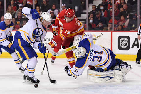 Mar 18, 2022; Calgary, Alberta, CAN; Buffalo Sabres defenseman Rasmus Dahlin (26) and goalie Dustin Tokarski (31) and Calgary Flames forward Matthew Tkachuk (19) during the third period at Scotiabank Saddledome. Sabres won 1-0. Mandatory Credit: Candice Ward-USA TODAY Sports