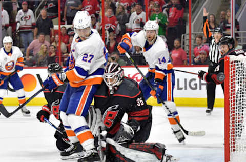 RALEIGH, NORTH CAROLINA – MAY 01: Curtis McElhinney #35 of the Carolina Hurricanes pushes Anders Lee #27 of the New York Islanders out of the crease during the third period of Game Three of the Eastern Conference Second Round during the 2019 NHL Stanley Cup Playoffs at PNC Arena on May 01, 2019 in Raleigh, North Carolina. The Hurricanes won 5-2. (Photo by Grant Halverson/Getty Images)