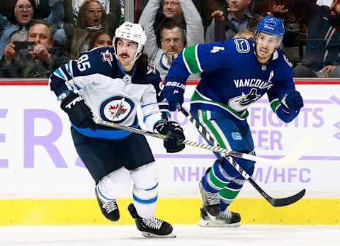 VANCOUVER, BC – NOVEMBER 19: Mathieu Perreault #85 of the Winnipeg Jets and Michael Del Zotto #4 of the Vancouver Canucks skate up ice during their NHL game at Rogers Arena November 19, 2018 in Vancouver, British Columbia, Canada. (Photo by Jeff Vinnick/NHLI via Getty Images)”n