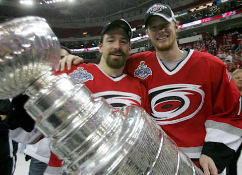 RALEIGH, NC – JUNE 19: Justin Williams #11 and Eric Staal #12 of the Carolina Hurricanes celebrate with the Stanley Cup after defeating the Edmonton Oilers in game seven of the 2006 NHL Stanley Cup Finals on June 19, 2006 at the RBC Center in Raleigh, North Carolina. The Hurricanes defeated the Oilers 3-1 to win the Stanley Cup finals 4 games to 3. (Photo by Jim McIsaac/Getty Images)