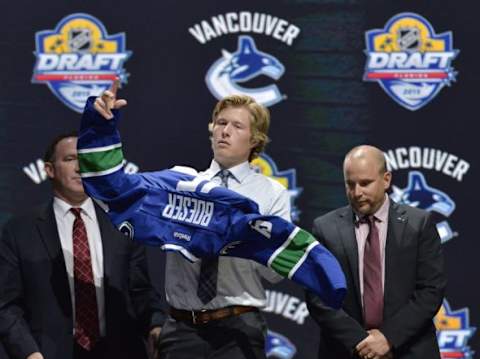 Jun 26, 2015; Sunrise, FL, USA; Brock Boeser puts on a team jersey after being selected as the number twenty-three overall pick to the Vancouver Canucks in the first round of the 2015 NHL Draft at BB&T Center. Mandatory Credit: Steve Mitchell-USA TODAY Sports