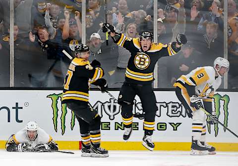 BOSTON – NOVEMBER 4: Boston Bruins’ Brad Marchand (63) celebrates his game-winning goal with teammate Patrice Bergeron (37) in front of Pittsburgh Penguins’ Sidney Crosby (87, on ice at left) and Brian Dumoulin (8) during the third period. The Boston Bruins host the Pittsburgh Penguins in a regular season NHL hockey game at TD Garden in Boston on Nov. 4, 2019. (Photo by Matthew J. Lee/The Boston Globe via Getty Images)