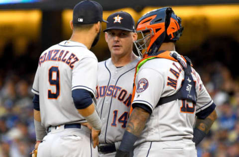 Manager AJ Hinch #14 stands on the mound with Marwin Gonzalez #9 and Martin Maldonado #15 of the Houston Astros. (Photo by Jayne Kamin-Oncea/Getty Images)