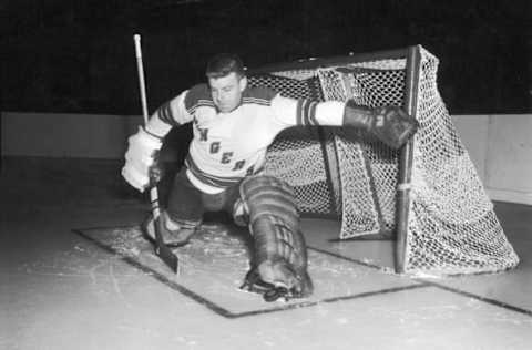 Canadian ice hockey player Lorne ‘Gump’ Worsley (1929 – 2007) (right), goalkeeper for the New York Rangers, makes a save, late 1950s or early 1960s. (Photo by Bruce Bennett Studios/Getty Images)