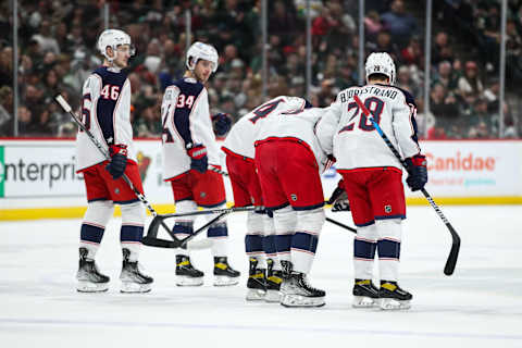 Mar 26, 2022; Saint Paul, Minnesota, USA; Columbus Blue Jackets defenseman Zach Werenski (8) is helped off the ice by teammates after suffering an apparent injury against the Minnesota Wild in the first period at Xcel Energy Center. Mandatory Credit: David Berding-USA TODAY Sports