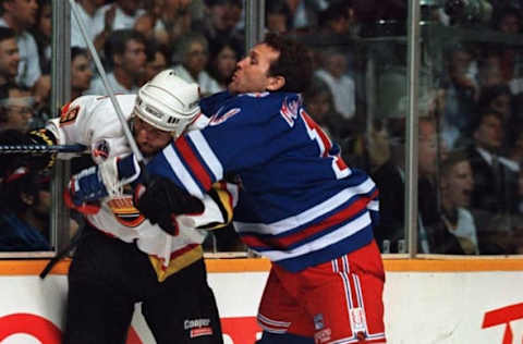 NEW YORK RANGERS FORWARD CRAIG MACTAVISH PUTS A HIT ON THE CANUCK”S TIM HUNTER