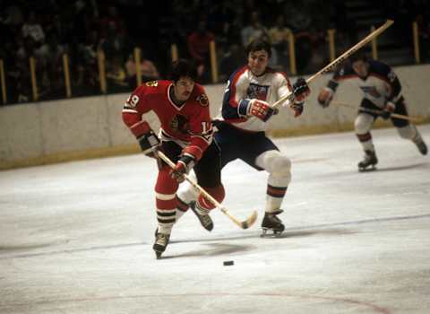 NEW YORK, NY – 1976: Dale Tallon #19 of the Chicago Blackhawks skates with the puck as Nick Fotiu #22 of the New York Rangers defends during their game circa 1976 at the Madison Square Garden in New York, New York. (Photo by B Bennett/Getty Images)