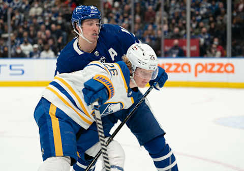 Mar 2, 2022; Toronto, Ontario, CAN; Toronto Maple Leafs right wing Mitchell Marner (16) battles with Buffalo Sabres defenseman Rasmus Dahlin (26) during the first period at Scotiabank Arena. Mandatory Credit: Nick Turchiaro-USA TODAY Sports