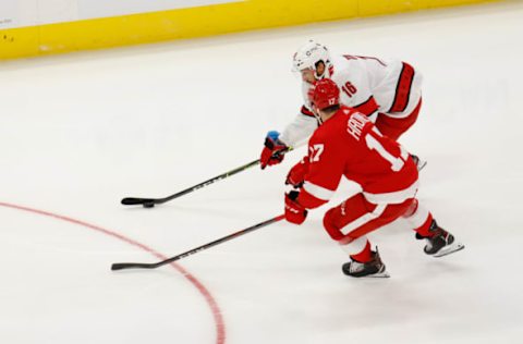 Jan 14, 2021; Detroit, Michigan, USA; Carolina Hurricanes center Vincent Trocheck (16) skates with the puck defended by Detroit Red Wings defenseman Filip Hronek (17) in the third period at Little Caesars Arena. Mandatory Credit: Rick Osentoski-USA TODAY Sports