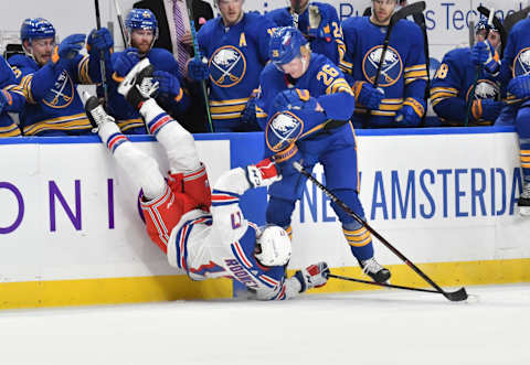 Jan 28, 2021; Buffalo, New York, USA; New York Rangers center Kevin Rooney (17) is upended by Buffalo Sabres defenseman Rasmus Dahlin (26) in the third period at KeyBank Center. Mandatory Credit: Mark Konezny-USA TODAY Sports