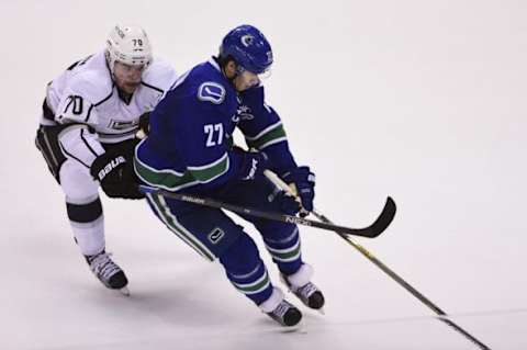 Dec 28, 2015; Vancouver, British Columbia, CAN; Los Angeles Kings forward Tanner Pearson (70) reaches over Vancouver Canucks defenseman Ben Hutton (27) during the third period at Rogers Arena. The Los Angeles Kings won 5-0. Mandatory Credit: Anne-Marie Sorvin-USA TODAY Sports