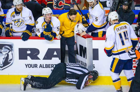 Jan 27, 2016; Calgary, Alberta, CAN; NHL linesman Don Henderson (91) after he was cross-checked by Calgary Flames defenseman Dennis Wideman (6) during the second period between the Calgary Flames and the Nashville Predators at Scotiabank Saddledome. Nashville Predators won 2-1. Mandatory Credit: Sergei Belski-USA TODAY Sports