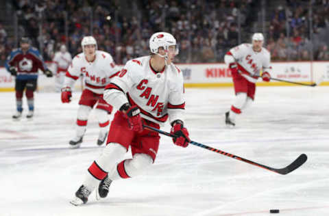 DENVER, COLORADO – DECEMBER 19: Sebastian Aho #20 of the Carolina Hurricanes advances the puck against the Colorado Avalanche in the third period at the Pepsi Center on December 19, 2019 in Denver, Colorado. (Photo by Matthew Stockman/Getty Images)