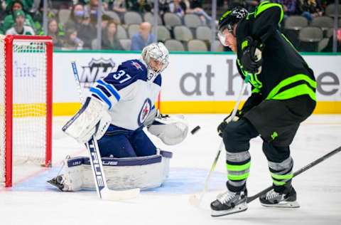 Feb 11, 2022; Dallas, Texas, USA; Winnipeg Jets goaltender Connor Hellebuyck (37) stops a shot by Dallas Stars center Joe Pavelski (16) during the second period at the American Airlines Center. Mandatory Credit: Jerome Miron-USA TODAY Sports