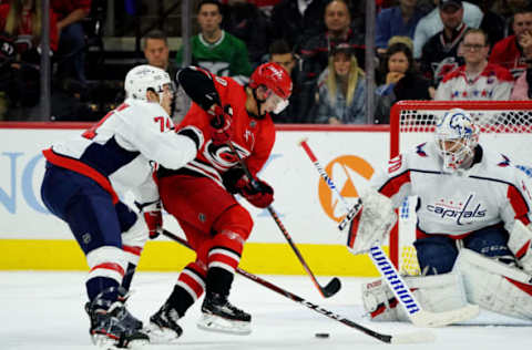 RALEIGH, NC – DECEMBER 28: Sebastian Aho #20 of the Carolina Hurricanes drives the crease as John Carlson #74 of the Washington Capitals defends and Braden Holtby #70 protects the net during an NHL game on December 28, 2019 at PNC Arena in Raleigh, North Carolina. (Photo by Gregg Forwerck/NHLI via Getty Images)