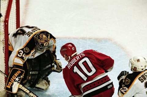 26 Apr 1999: Goalie Byron Dafoe #34 of the Boston Bruins blocks the shot to the goal by Gary Roberts #10 of the Carolina Hurricanes during the Eastern Conference Quarter Finals Game Three at the Fleet Center in Boston, Massachusetts. The Hurricanes defeated the Bruins 2-1.