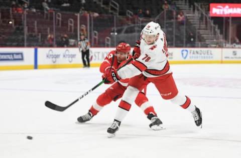 Mar 14, 2021; Detroit, Michigan, USA; Carolina Hurricanes center Steven Lorentz (78) shoots as Detroit Red Wings left wing Darren Helm (43) defends during the first period at Little Caesars Arena. Mandatory Credit: Tim Fuller-USA TODAY Sports