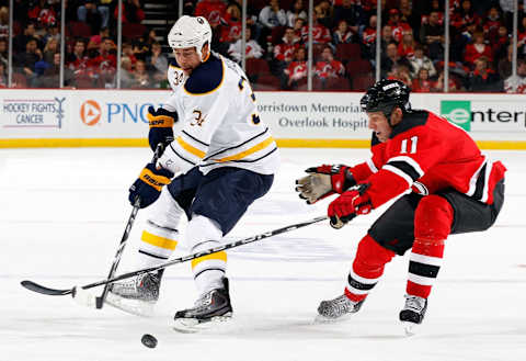 NEWARK, NJ – OCTOBER 23: Chris Butler #34 of the Buffalo Sabres battles for control of the puck against Adam Mair #11 of the New Jersey Devils on October 23, 2010 at the Prudential Center in Newark, New Jersey. (Photo by Mike Stobe/Getty Images)