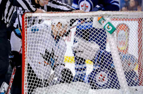 WINNIPEG, MB – FEBRUARY 5: Tomas Hertl #48 of the San Jose Sharks and goaltender Connor Hellebuyck #37 of the Winnipeg Jets get themselves untangled from the net following a collision during third period action at the Bell MTS Place on February 5, 2019 in Winnipeg, Manitoba, Canada. The Sharks defeated the Jets 3-2 in overtime. (Photo by Darcy Finley/NHLI via Getty Images)