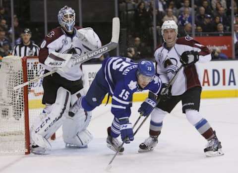 Nov 17, 2015; Toronto, Ontario, CAN; Colorado Avalanche goaltender Reto Berra (20) and defenseman Tyson Barrie (4) knock down Toronto Maple Leafs forward P.A. Parenteau (15) during the second period at the Air Canada Centre. Mandatory Credit: John E. Sokolowski-USA TODAY Sports