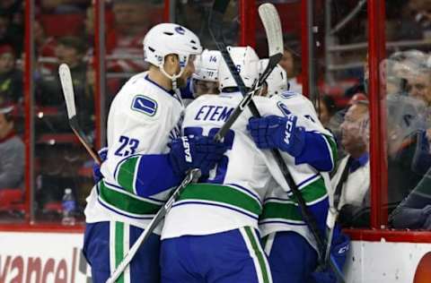 Jan 15, 2016; Raleigh, NC, USA; Vancouver Canucks forward Linden Vey (7) is congratulated by his teammates forward Emerson Etem (26) defensemen Alexander Edler (23) and forward Alexandre Burrows (14) after his first period goal against the Carolina Hurricanes at PNC Arena. Mandatory Credit: James Guillory-USA TODAY Sports