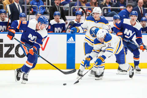 Mar 25, 2023; Elmont, New York, USA; New York Islanders center Brock Nelson (29) and Buffalo Sabres right wing Kyle Okposo (21) fight for control of the puck in the third period at UBS Arena. Mandatory Credit: Wendell Cruz-USA TODAY Sports