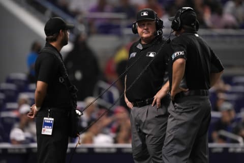 MLB first base umpire Bill Miller (C) and second base umpire Brian Knight (R) review a play in the 9th inning between the Miami Marlins and the San Diego Padres. Mandatory Credit: Jasen Vinlove-USA TODAY Sports