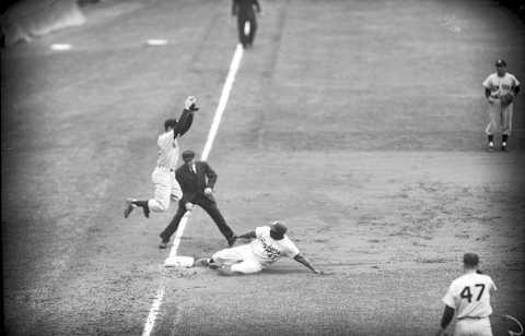 BROOKLYN, NY – SEPTEMBER 30: Jackie Robinson #42 of the Brooklyn Dodgers slides into third base ahead of the throw to Gil McDougald #12 of the New York Yankees during a World Series game on September 30, 1955 at Ebbets Field in Brooklyn, New York. Johnny Podres and the Dodgers won the third game of the series, 8-3, in front of 34,209 fans. (Photo by Kidwiler Collection/Diamond Images/Getty Images)